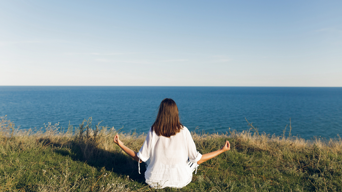 A women doing meditation in infront of a river