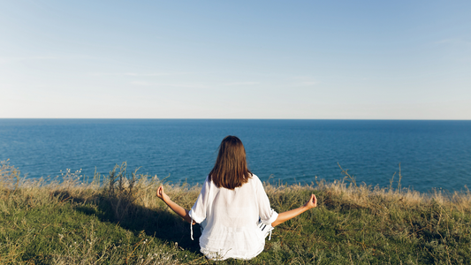 A women doing meditation in infront of a river