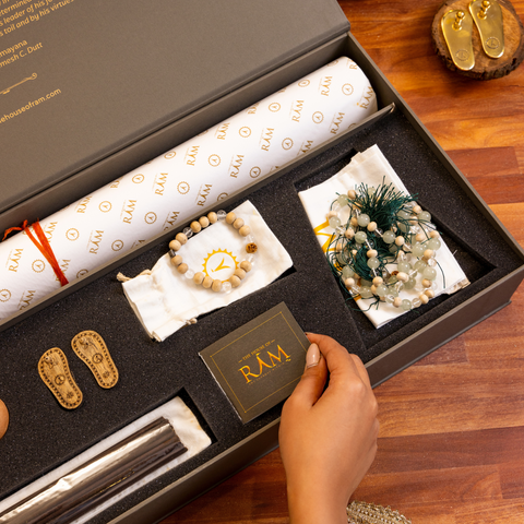 A beautifully designed gift box from The House of Ram featuring premium incense sticks, prayer beads, decorative miniature sandals, and sacred accessories, all arranged in an elegant and luxurious presentation. A beautifully designed gift box from The House of Ram featuring premium incense sticks, prayer beads, decorative miniature sandals, and sacred accessories, all arranged in an elegant and luxurious presentation.
