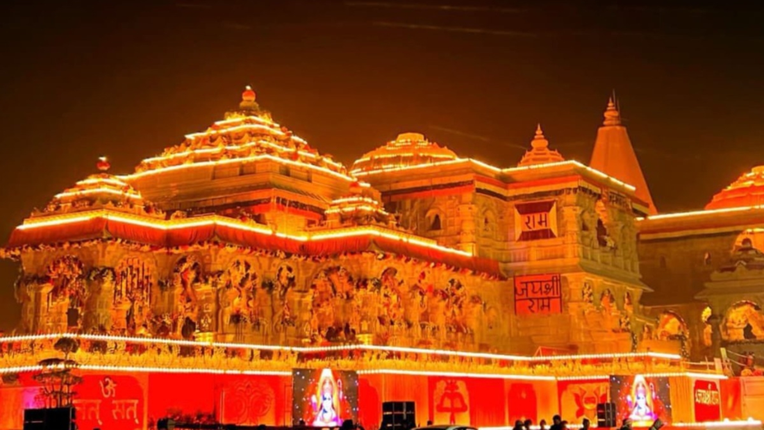 A beautifully illuminated temple at night, adorned with intricate carvings and banners, celebrating Hindu deities.