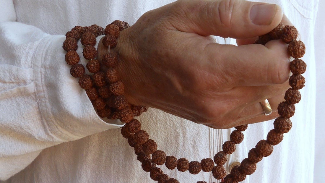 A person holding rudraksh mala