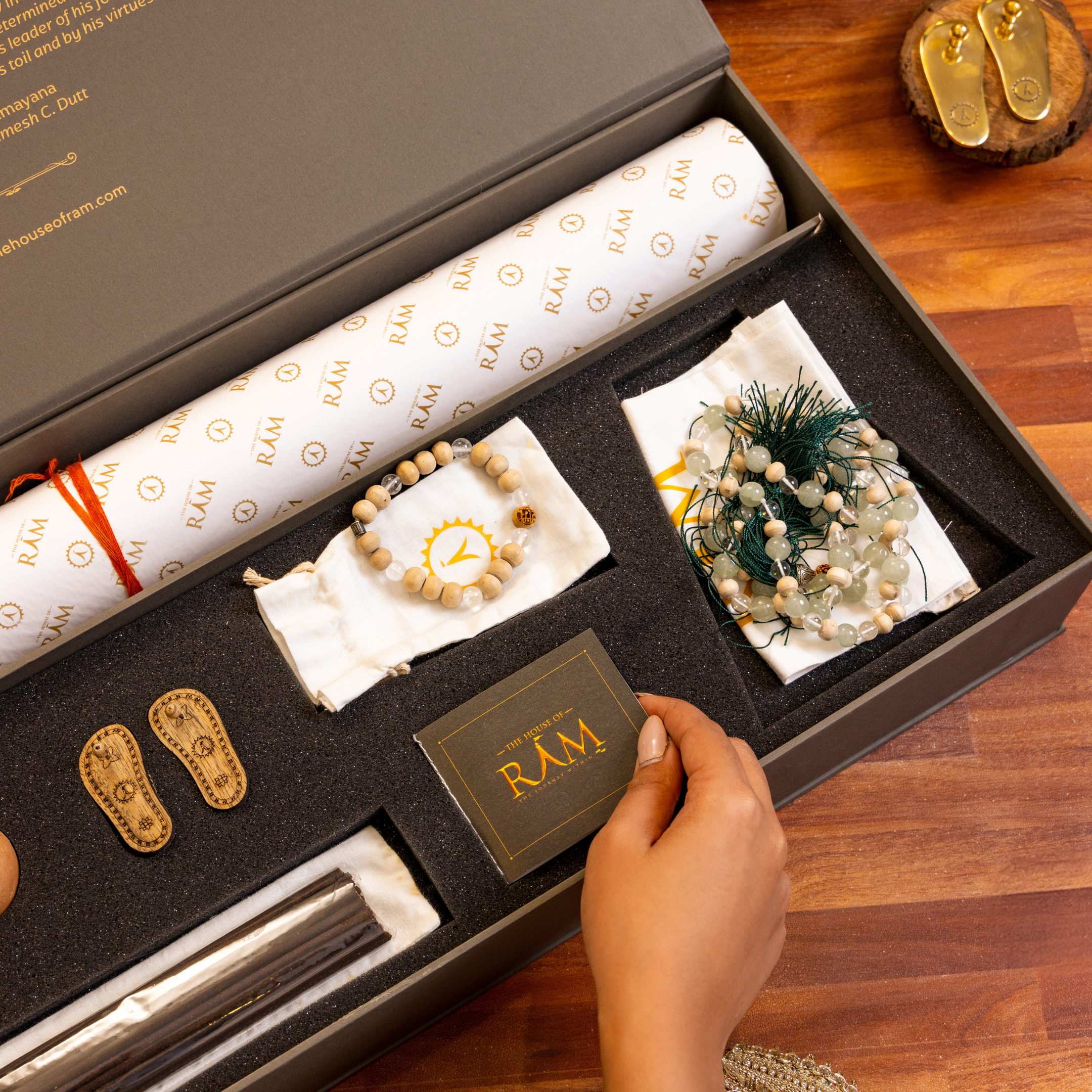 A beautifully designed gift box from The House of Ram featuring premium incense sticks, prayer beads, decorative miniature sandals, and sacred accessories, all arranged in an elegant and luxurious presentation.